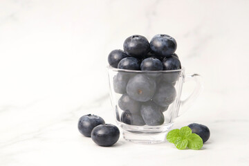 Fresh blueberries with mint leaves. The fruits are actual berries with many tiny seeds and are deep indigo to black color when ripe. Copy space.