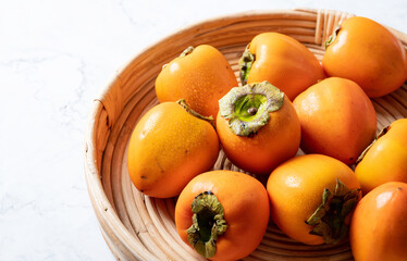Persimmons on a wooden plate
