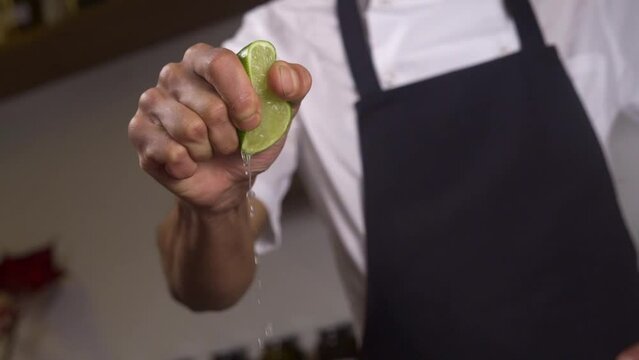 Unrecognizable cheff squeezing a lime by hand