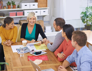 Starting the day off with an informal meeting. a group of colleagues sitting around a table.