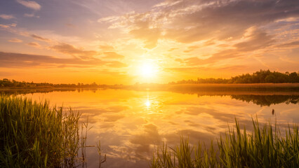 Naklejka na ściany i meble Scenic view of beautiful sunset or sunrise above the pond or lake at spring or early summer evening.