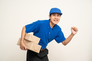 Asian man in blue uniform standing holding box parcel cardboard and smartphone on isolated white background. Male service worker with cell phone. Delivery courier shipping service