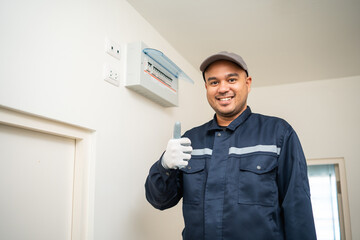 Portrait electrician man in uniform maintenance or fixing switches sockets  circuit breaker electrical system. Technician fixing an electric fuse at home. Home service concept.