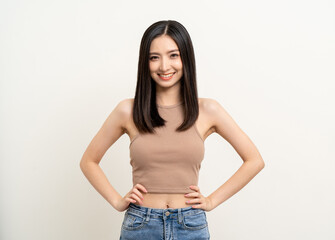 Fototapeta premium Beautiful smiling happy young asian woman age around 25 in brown shirt. Charming female lady standing pose on isolated white background. Asian cute people looking camera confident with white backdrop.