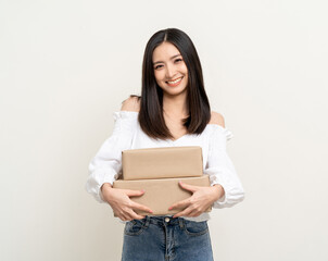 Young excited beautiful asian woman with parcel cardboard standing on isolated background. Cheerful female holding lot of parcel box receive from the delivery service shopping online application
