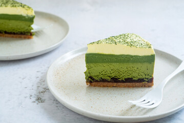 Matcha layer cheesecake top with whipped cream with a sprinkle of matcha powder on top