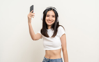 Beautiful young asian women choose song and play music from smartphone connection with wireless headphone having fun. Teenage girl listen to the music enjoy relaxing on isolated white background.