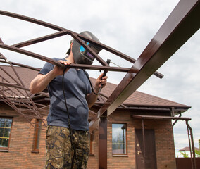 The worker installs the metal on the canopy.