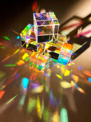 Cubic coloured dichroic glass disperse narrow beam of artificial light into colourful spectrum on...