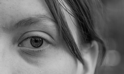 Part of a girl's face with an eye and a curl of hair