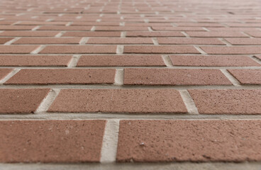 Modern and stylish orange red and brown colored brick pattern textures are regularly listed and stacked with a pile of stone material background used outfocusing