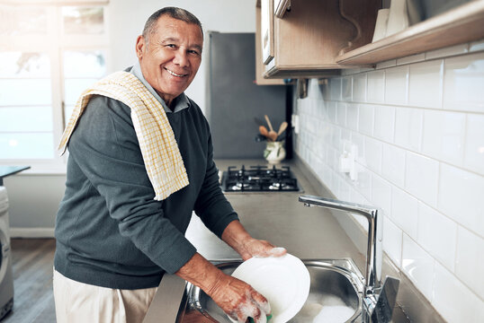 Cleaning, washing dishes or portrait of happy old man with soap water in kitchen sink in healthy home. Dirty, smile or senior male with liquid foam to disinfect, protect or prevent bacteria or germs - Powered by Adobe