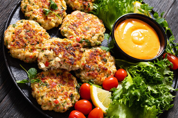 crab cakes with sauce, lettuce, tomatoes, lemon