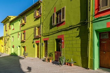 Fototapeta na wymiar The colorful typical houses of Via di Mezzo street, Ghizzano, Pisa, Italy