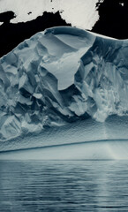 Massive Iceberg In Antarctica Looks Textured and Chiseled, Unique Shapes, Moody Landscape, Mirrored in Water