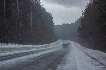 Snow-covered road with ice in the forest in the Urals