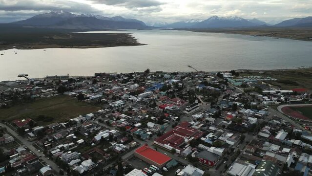 City of Puerto Natales Chile, Aerial Drone Above Town Buildings Amongst Patagonian Landscape of Idyllic Bay Water and Andean Cordillera Background