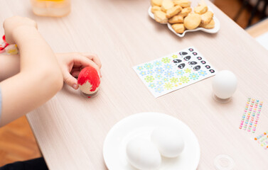 Child hands painting easter eggs, selective focus. Happy Easter concept. Process of crafting at...