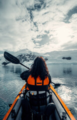 Female Kayaker Navigates Her Way Through Calm Waters of Antarctica on Sunny and Moody Day