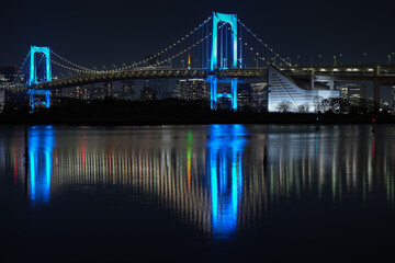 Rainbow Bridge in blue light color, night photo with the landmarks of Tokyo city from Japan. Tokyo skyline landscape in the night.