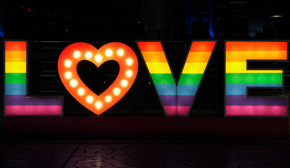 Love text under rainbow color light. Concept message for the LGBTQ community, acceptance and respect for each of us.
