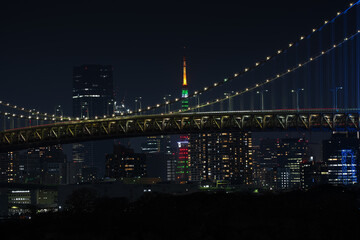 Rainbow Bridge in blue light color, night photo with the landmarks of Tokyo city from Japan. Tokyo skyline landscape in the night.