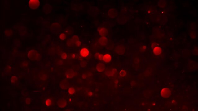 Slow Motion Of Red Bokeh Lights. Abstract motion background of defocused red circles. Natural bokeh effect of light leaks on blur glitters.