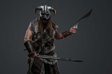 Portrait of ancient scandinavian warrior with dual swords staring at camera.