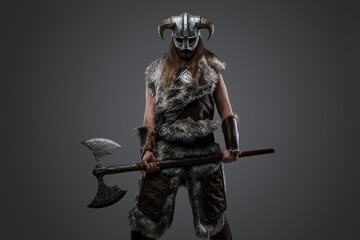 Shot of barbarian from north with fur and long hairs holding huge axe.