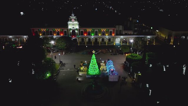 Illuminated Christmas Tree In Front Of City Hall Of Ciudad Guzman At Night In Jalisco, Mexico. aerial static