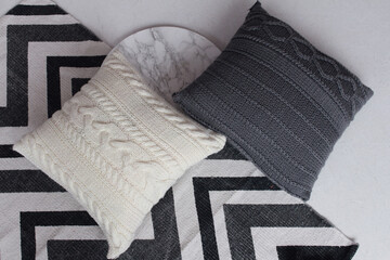 Soft comfortable beautiful knitted pillows on the floor. Geometric picture.