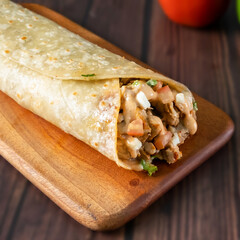 Thai Chicken Wrap paratha roll served in wooden board side view of indian fastfood
