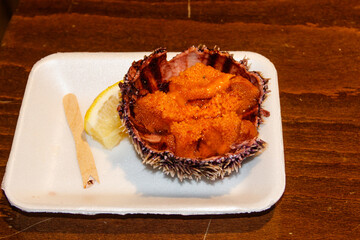 Fresh sea ​​urchin with lemon on wooden table