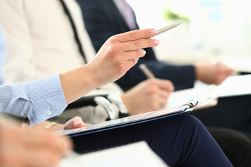 Row of business people hands holding documents and pens with documents