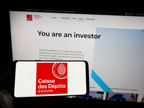 Stuttgart, Germany - 03-12-2023: Person holding cellphone with logo of Caisse des Depots et Consignations (CDC) on screen in front of webpage. Focus on phone display.