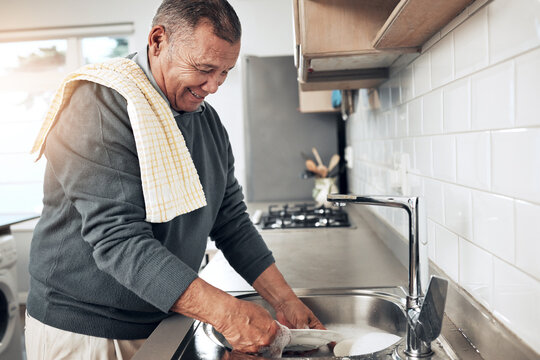 Cleaning, washing dishes or happy old man with soap and water in the kitchen sink in healthy home. Dirty, messy or senior person with liquid foam to disinfect, protect and prevent bacteria or germs - Powered by Adobe