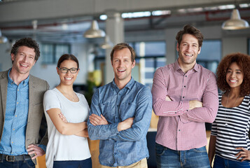 Were a team that stand by each other. A row of friendly looking professionals in their office posing proudly.