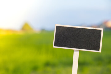 Blank Black billboard against green field landscape Empty mockup template Blackboard label at farm land. Copy space banner for your text. Agricultural landscape Summer landscape with hilly field
