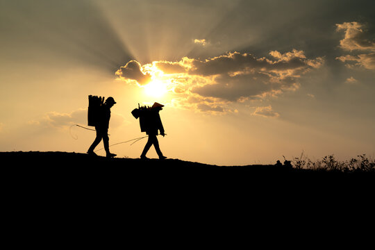 Silhouettes of ethnic minorities on their way back home at sunset in Pleiku town, Gia Lai province, Vietnam.