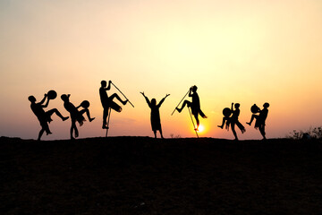 Silhouettes of Ede boys and girls performing their traditional dance during sunset in Pleiku town, Gia Lai province, Vietnam.