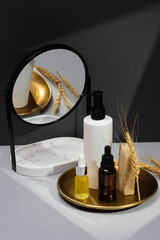 Set of essential oils, handmade soap and mirror on a dark gray background. Creative still life with organic cosmetics. The concept of selfcare and organic products. Reflection in the mirror