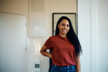 Young happy black woman at home looking at camera.