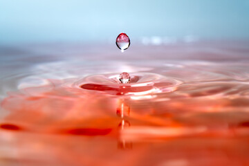 Moment of water drops colliding on pink background. Abstract natural background