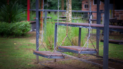 Fototapeta na wymiar rustic empty swing in park with vignette