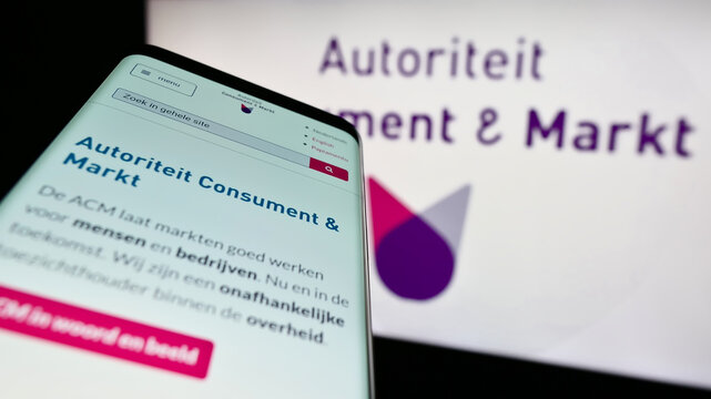 Stuttgart, Germany - 03-12-2023: Mobile phone with website of Dutch regulator Autoriteit Consument en Markt (ACM) on screen in front of logo. Focus on top-left of phone display.