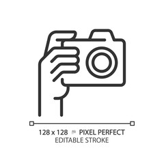 Hand with camera pixel perfect linear icon. Person taking shot with analog equipment. Photographer tool. Thin line illustration. Contour symbol. Vector outline drawing. Editable stroke