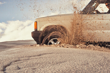 Pushing through the desert. a heavy duty 4x4 driving along some sand dunes. © Jeff B/peopleimages.com