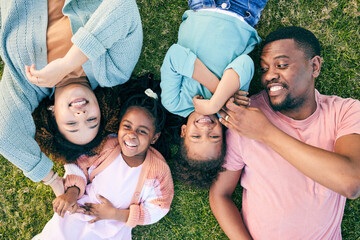 Top view, black family and parents with kids on grass, carefree and happiness on vacation, relax and smile. Mother, father and children in park, freedom and playful together, love and bonding outdoor