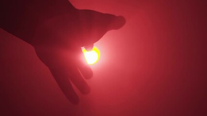 Vertical video - hand reach out toward light, red background, struggling concept