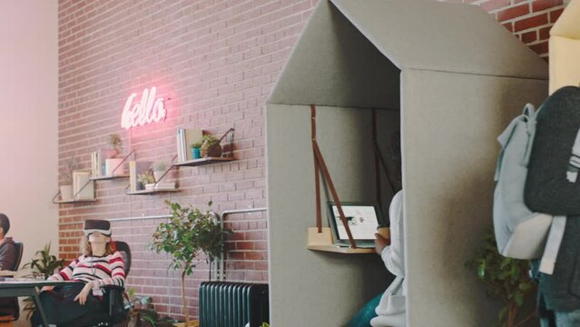 Technology, creative workspace and business people in cubicle in busy, startup and modern office. Teamwork, web design company and young employees working with virtual reality, tablet and computer